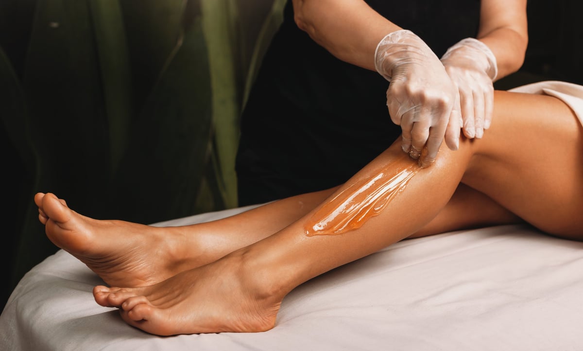 Young woman having professional waxing hair removal treatment at spa salon